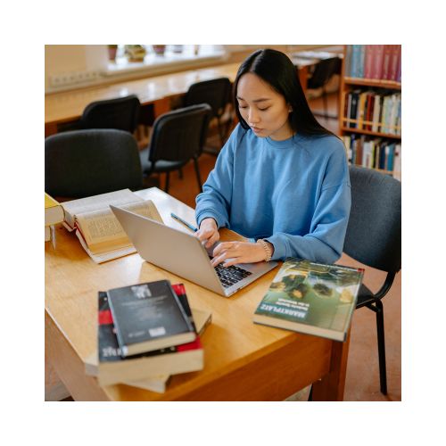 student with notes and laptop